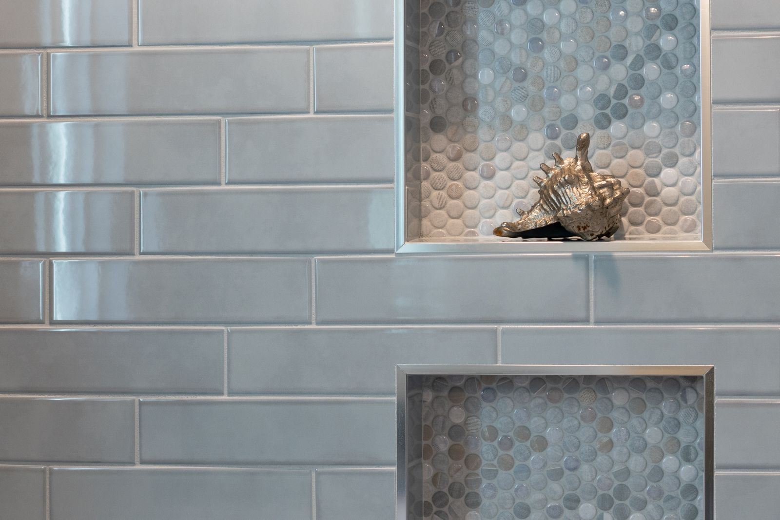 Tiled shower wall with a recessed niche, grout lines clean and even